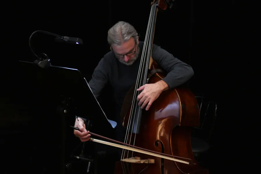 Zdjęcie przedstawia muzyka Tomasza Wilczyńskiego grającego na kontrabasie 