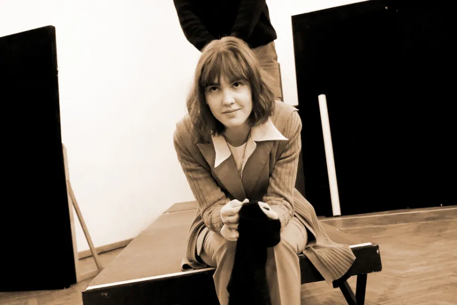 zdjęcie przestawia dwoje aktorów: Dariusza Bereskiego i Szantal Strzelińską. Aktorka siedzi na podeście, w rękach trzyma czarny materiał, patrzy w aparat. Aktor stoi nad nią.  