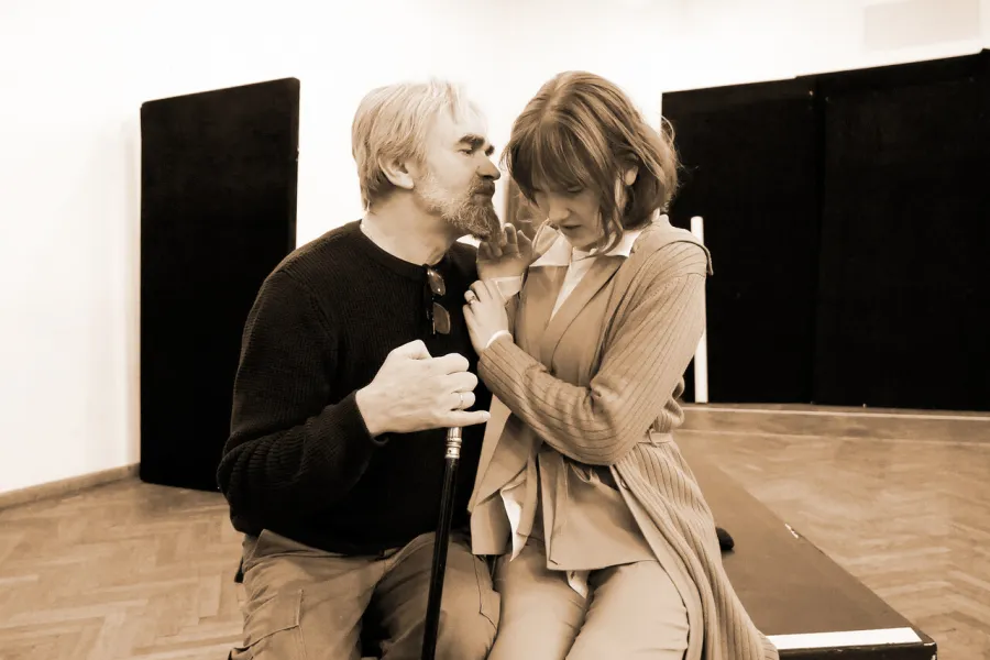 zdjęcie przestawia dwoje aktorów: Dariusza Bereskiego i Szantal Strzelińską siedzących na podeście. Aktor obejmuje mocno aktorkę, przyciskając ją do siebie. 