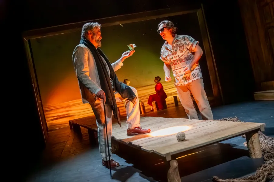 na pomoście jedną nogą stoi Dariusz Bereski, w ręku trzyma plik pieniędzy. Po drugiej stronie pomostu stoi aktor Konrad Krupiński. 