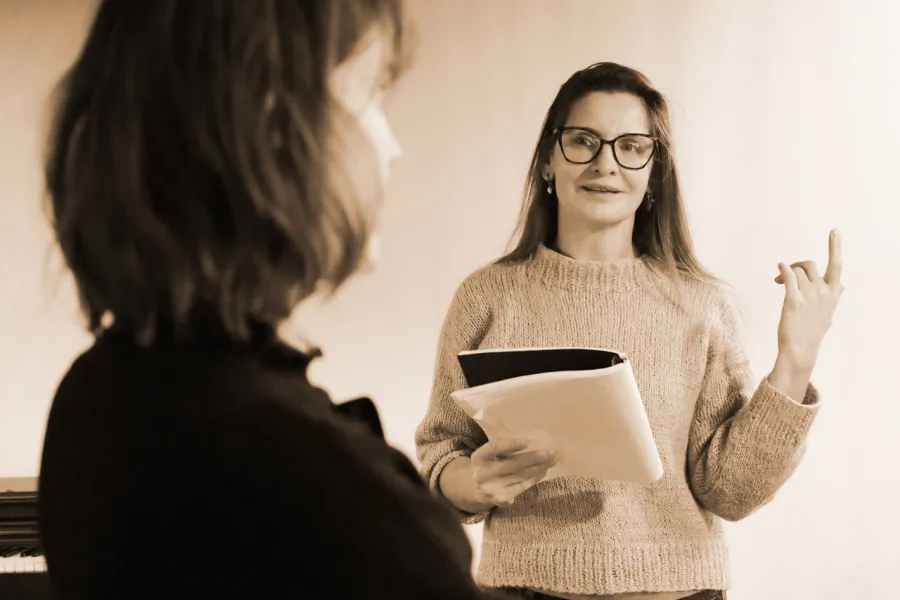 Zdjęcie z próby spektaklu „Zamiana". Jedna z nich w rękach trzyma scenariusz.