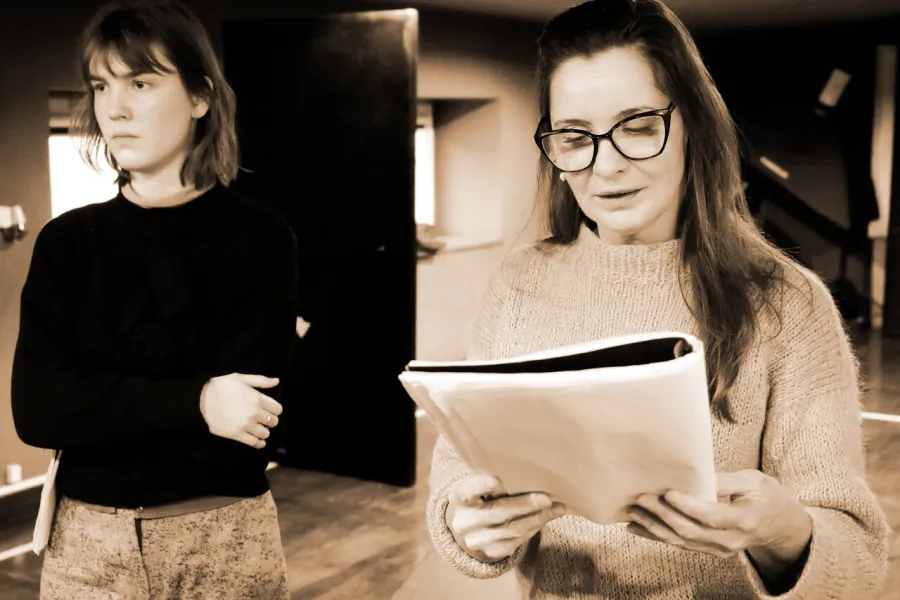 Zdjęcie z próby spektaklu „Zamiana". Jedna z nich w rękach trzyma scenariusz.
