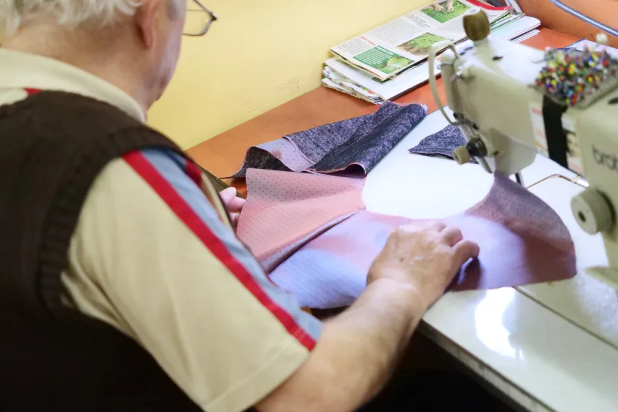 przygotowania do premiery „Świętoszka", pracownia krawiecka, Na zdjęciu krawiec pracujący nad materiałem, przy maszynie do szycia, fot. Marcin Nowak