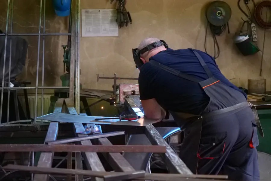 przygotowania do premiery „Świętoszka", ślusarnia. Na zdjęciu pracownik spawający metalowe elementy scenografii, fot. Marcin Nowak