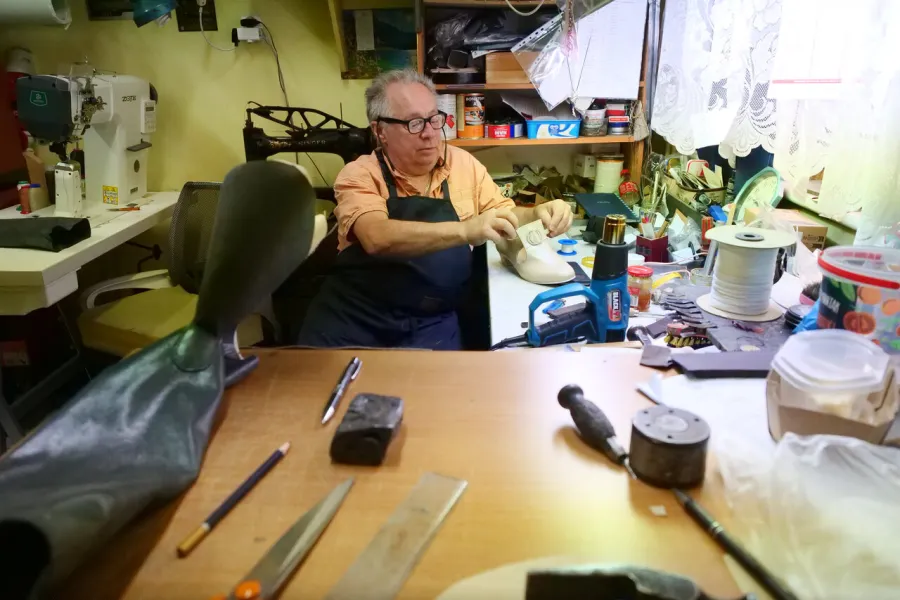 przygotowania do premiery „Świętoszka", pracownia szewska. Na zdjęciu szewc siedzący i pracujący nad butami dla jednego z aktorów, fot. Marcin Nowak