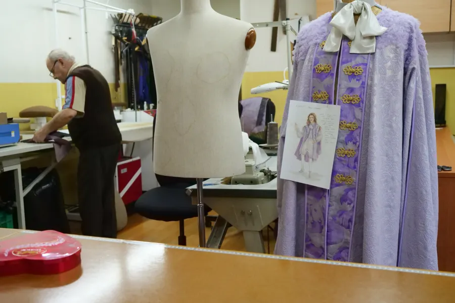 przygotowania do premiery „Świętoszka", pracownia krawiecka. Na pierwszym planie widać manekiny, na jednym z nich wisi gotowy kostium, a na nim przyczepiona kartka z projektem kostiumu. W tle widać pracownika, który pracuje nad kolejnym kostiumem. fot. Marcin Nowak