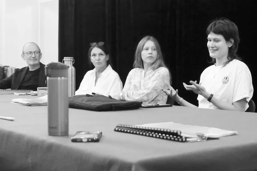 pierwsza próba spektaklu „Czas na wielki numer", na zdjęciu od lewej przy stole siedzą: dyrektor Paweł Łysak, aktorka Monika Badowska, aktorka Matylda Paszczenko, reżyserka Barbara Bendyk, która gestykuluje opowiadając o spektaklu, na zdjęcie nałożony jest czarno-biały filtr, fot. Marcin Nowak 