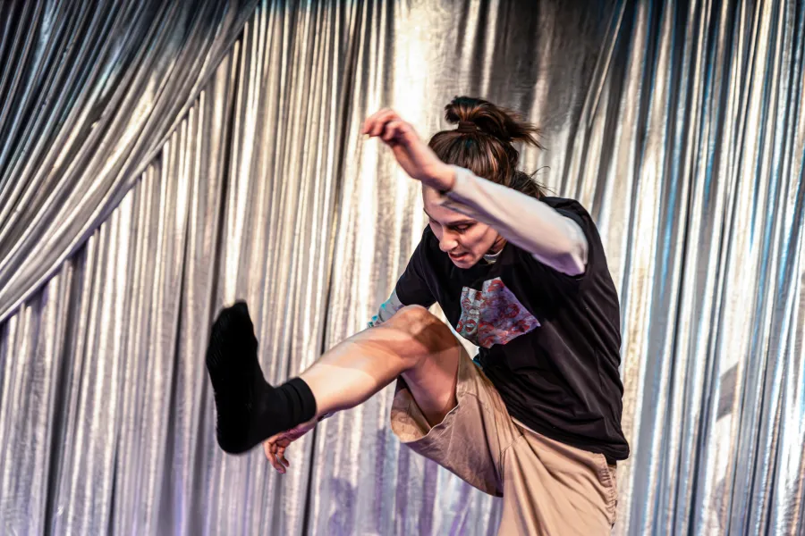 Zdjęcie ze spektaklu „Czas na wielki numer". Na fotografii sktorka Natalia Klepacka jest uchwycona w pozie jakby walczyła. Prawą nogę ma wysuniętą do przodu jakby zadawała nią cios. Lewą rękę ma uniesioną do góry. Jej sylwetka jest pochwylona do przodu. Autorką zdjęcia jest Natalia Kabanow